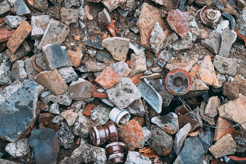 地面に散らばる割れた陶器の破片と廃棄物