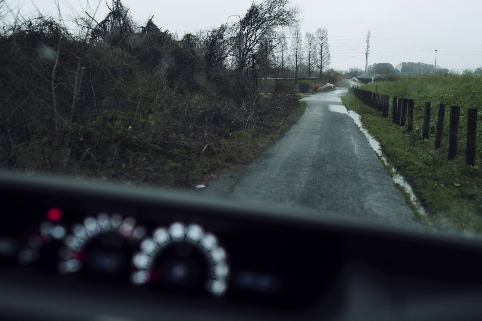 雨の農道を車内から見た風景、フロントガラスに雨粒