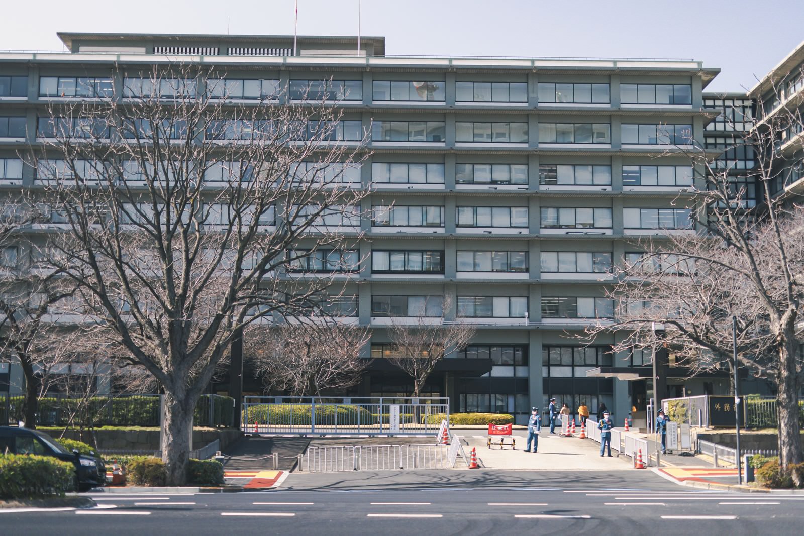 外務省庁舎の出入り口前の風景、白い大型の官庁建物と歩道