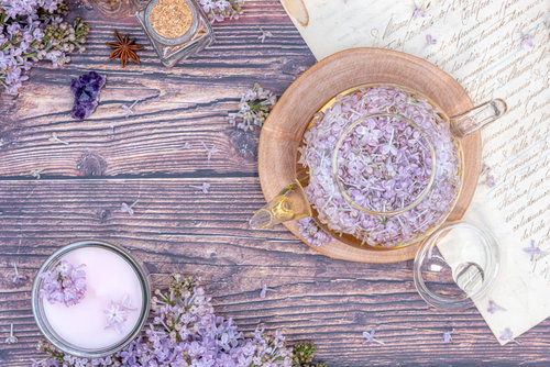 ライラックの花を浮かべたティーポットとハーブティー