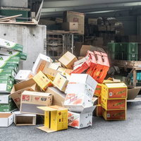 市場に乱雑に積み重ねられた段ボール箱と梱包材の写真