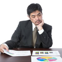 しょうもないプレゼン資料にため息をつく部長が数字をチェックの写真