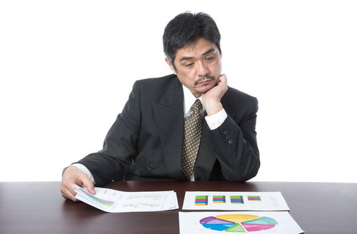 しょうもないプレゼン資料にため息をつく部長が数字をチェック