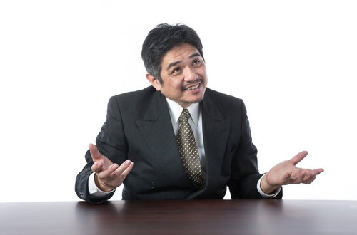 笑顔で説明するスーツ姿の年配上司