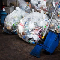 回収されたゴミ袋と青いちりとり、清掃道具一式の写真