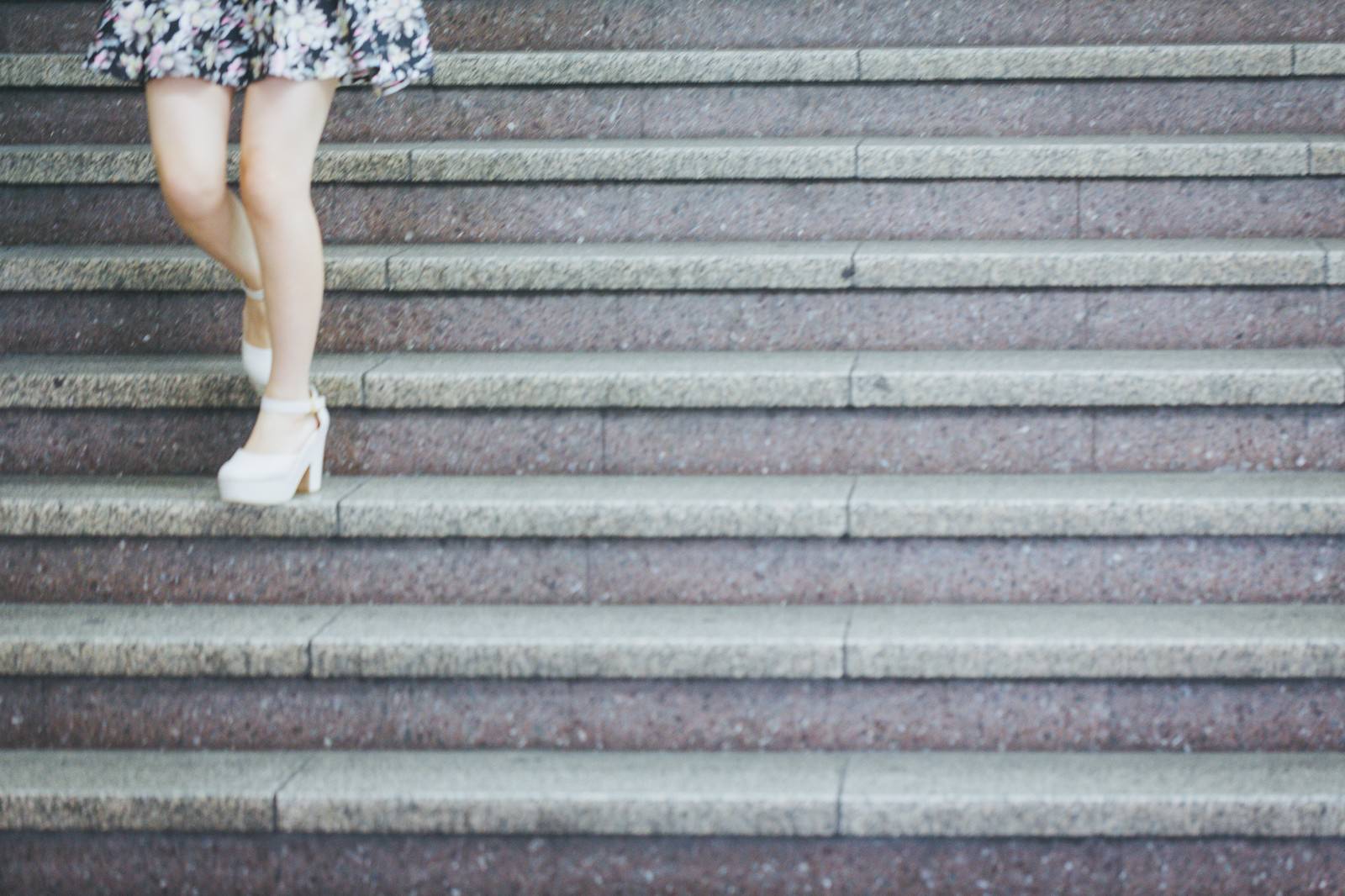 白いブーツで石段を下りる女性の足元