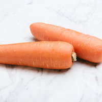 マーブル天板に並べた新鮮なにんじん2本、採れたての根菜の写真