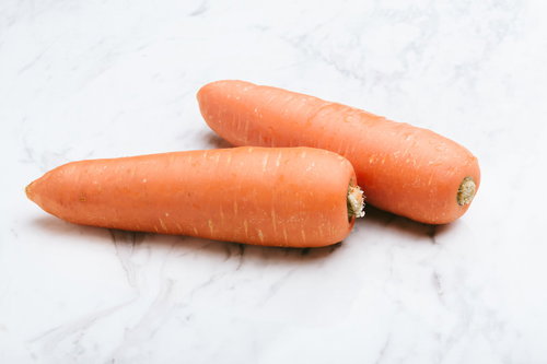 マーブル天板に並べた新鮮なにんじん2本、採れたての根菜