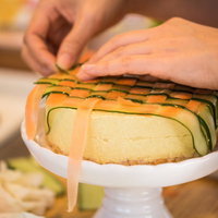 ズッキーニと人参の薄切りを交互にのせるベジデコケーキの写真