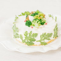 ブロッコリーのデコレーションと春菊に包まれた「ベジデコグリーンケーキ」の写真