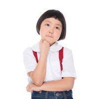 遠足のおやつを考える小学生の女の子が悩む表情の写真