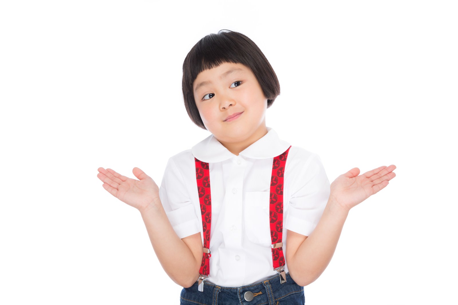 白いシャツと赤いサスペンダーを着けたおかっぱ髪の女の子が、両手を広げてジェスチャーでアピールしている［モデル：ゆうき］
