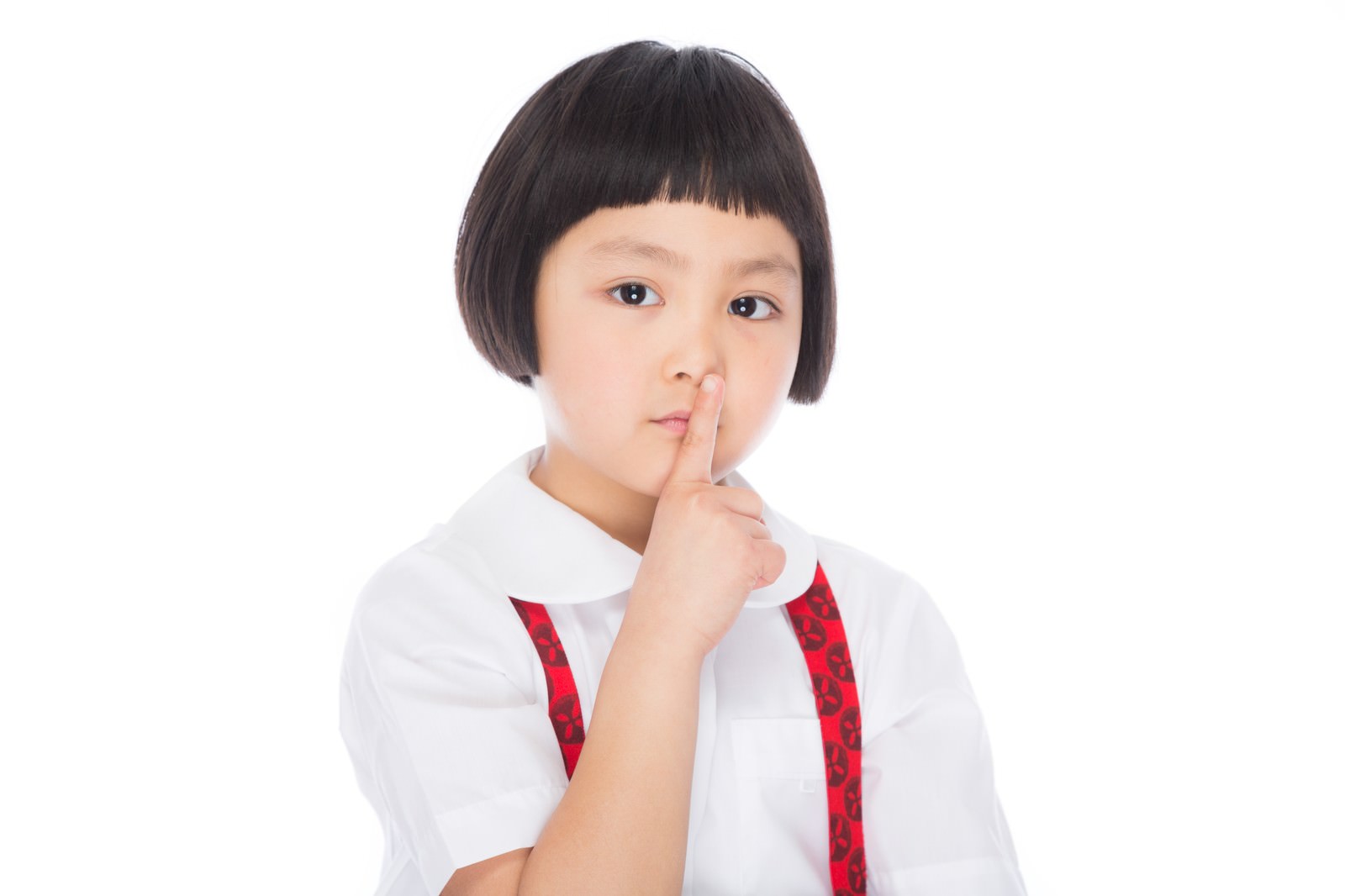 白いシャツと赤いリボンを着けた前髪パッツンの女の子が、指を唇に当てて沈黙のポーズをしている［モデル：ゆうき］