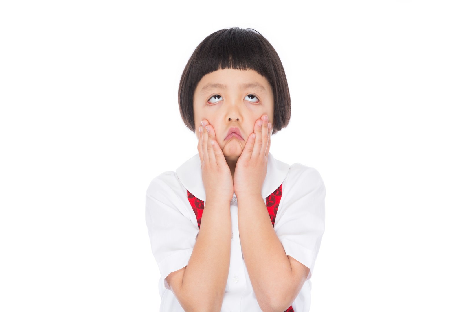 両頬に手を当てて不満そうな顔をする前髪パッツンの女の子［モデル：ゆうき］