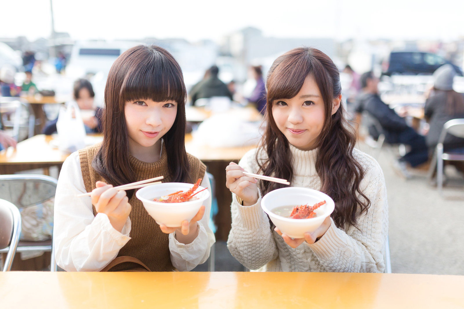 朝市でイセエビ味噌汁を食べる女性観光客が白い丼ぶりを両手で持っている［モデル：河村友歌 渡辺友美子］