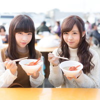 朝市でイセエビの味噌汁をいただく女性観光客の写真