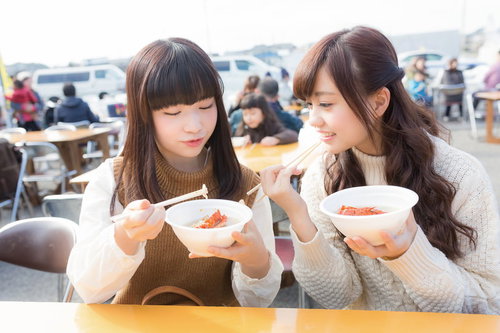 いすみ市の朝市フードコートで伊勢海老のお吸い物を食べる女性二人