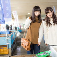 いすみ市の朝市で地元の特産品を見て回る女性観光客の写真