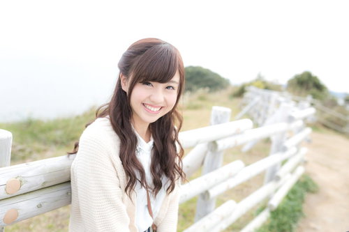 白いフェンス越しに笑顔が眩しい女性モデル