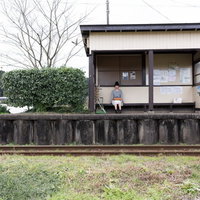 いすみ鉄道新田野駅の無人駅舎で待つ女性と地方の風景の写真