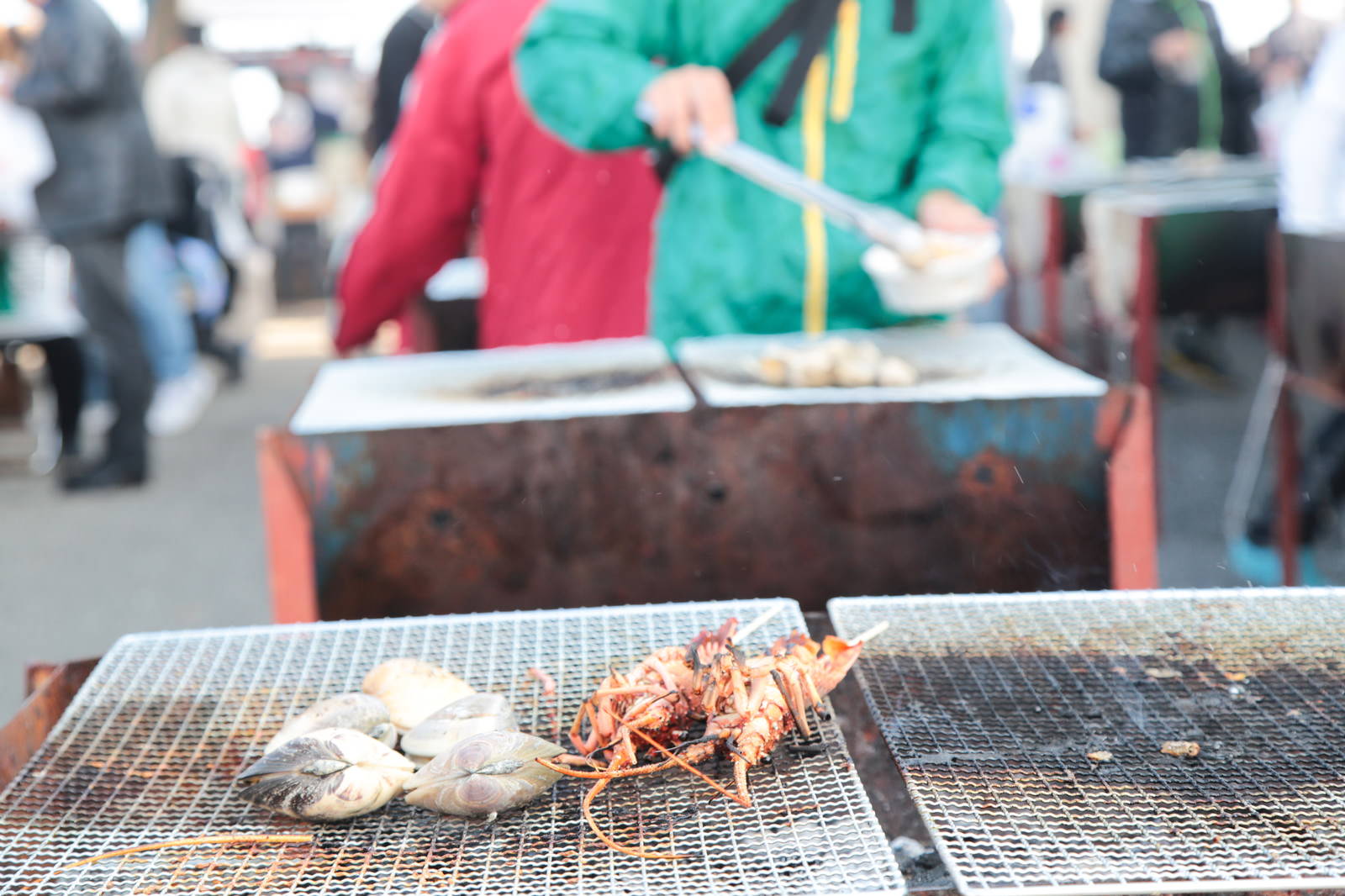いすみ市の港の朝市で伊勢海老とハマグリを網焼きで調理する様子