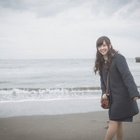 彼女と冬の海デート、波打ち際で笑顔を浮かべるの写真