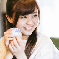 伊万里焼のおちょこで日本酒を飲む観光客の女性の写真