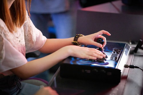 アケコンを操作する女性ゲーマーの手元とボタン操作