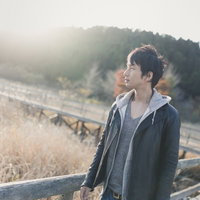 夕暮れのトンボ池で遠くを見つめる男性の写真