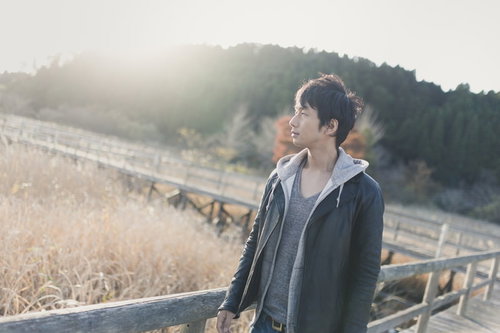 夕暮れのトンボ池で遠くを見つめる男性