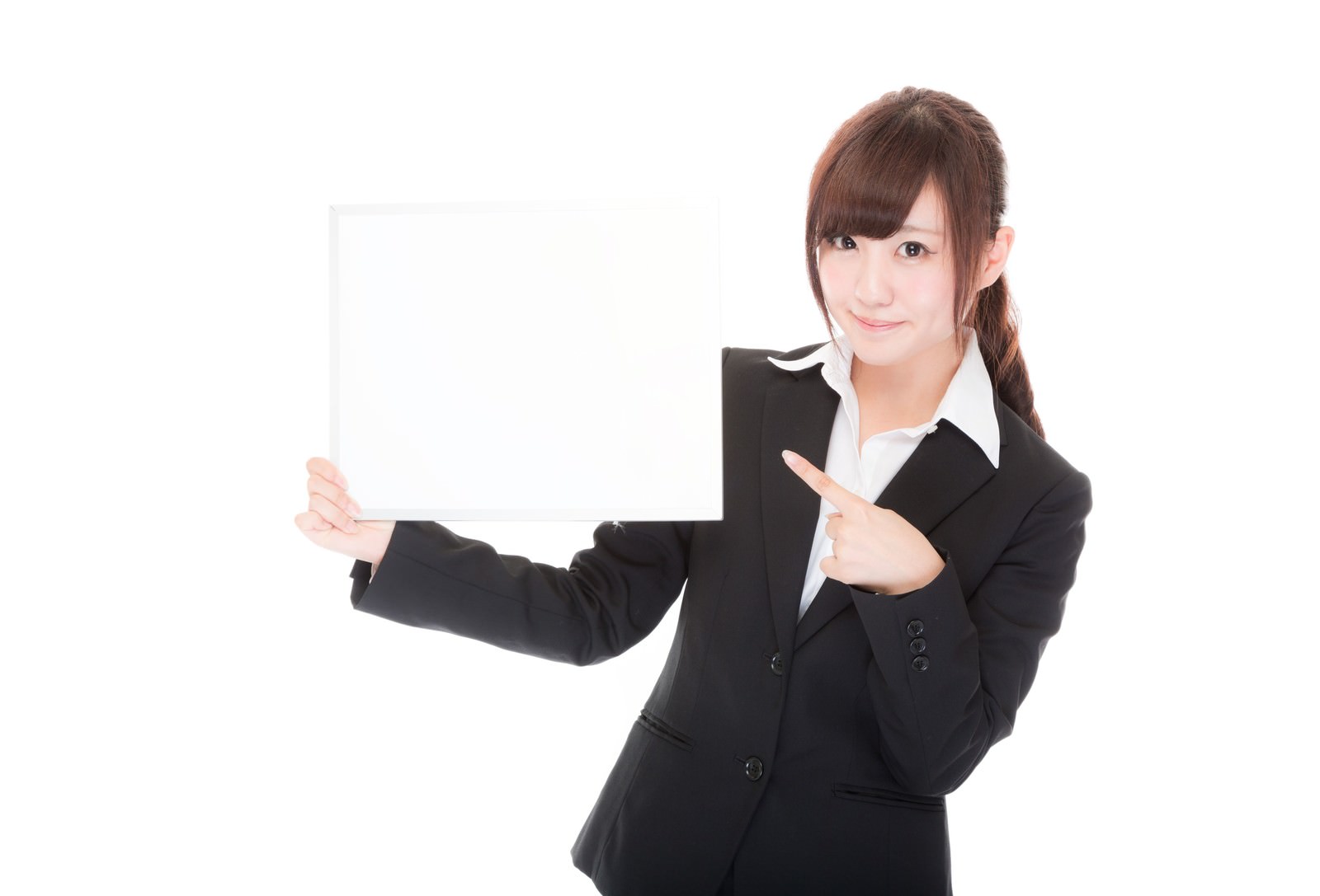 スーツを着た女性がボードを持ちながら指をさして案内している［モデル：河村友歌］