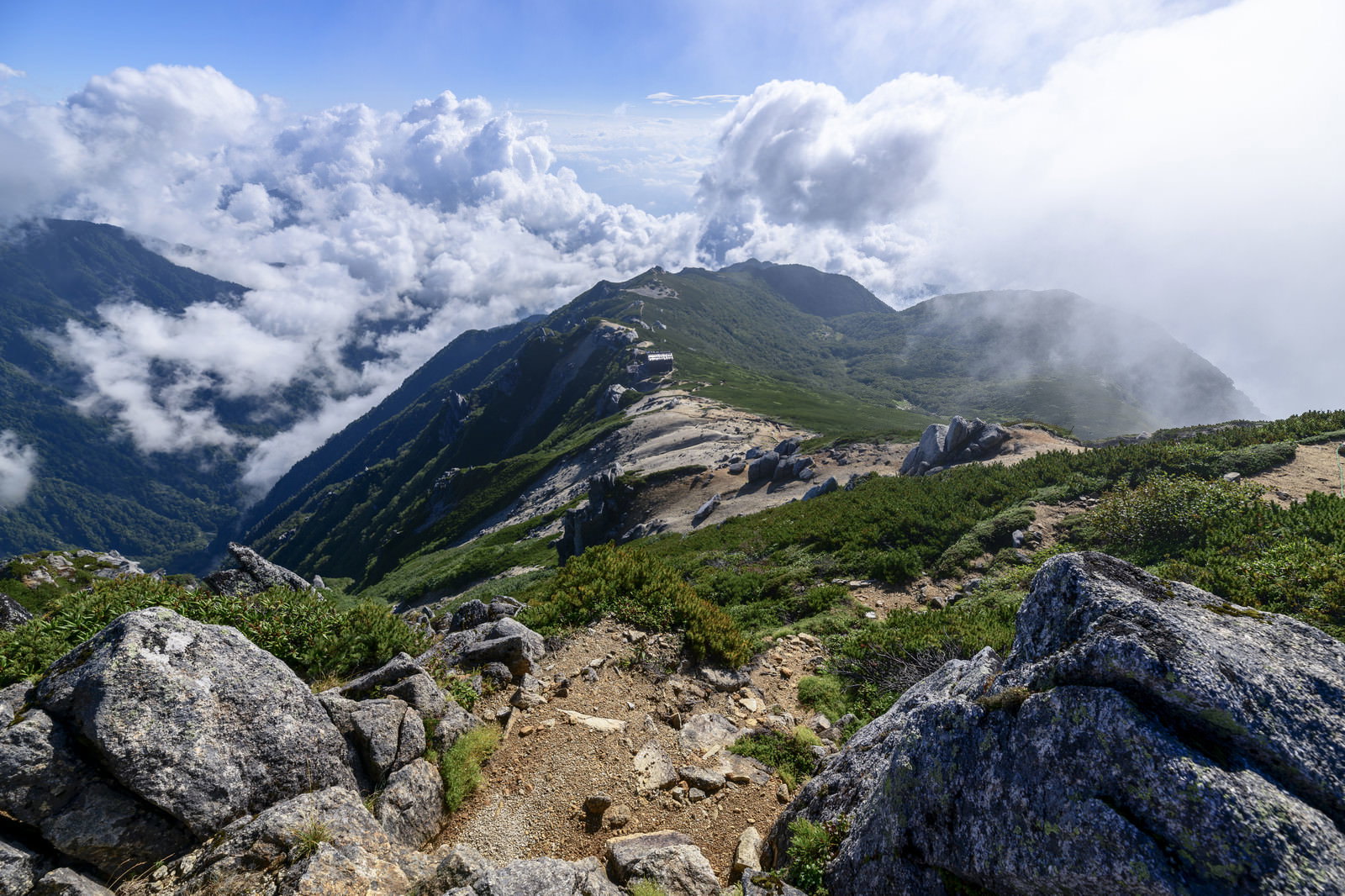 雲に包まれる中央アルプス空木岳の駒峰ヒュッテと稜線の山岳風景