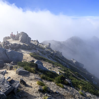 晴れた山頂に湧き上がる雲海と空木岳の登山者の写真