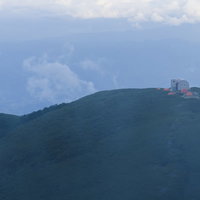 中央アルプスの霧の向こうに立つ檜尾岳の避難小屋の写真