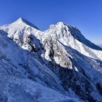 文三郎尾根の途中から見る雪の阿弥陀岳と中岳の写真