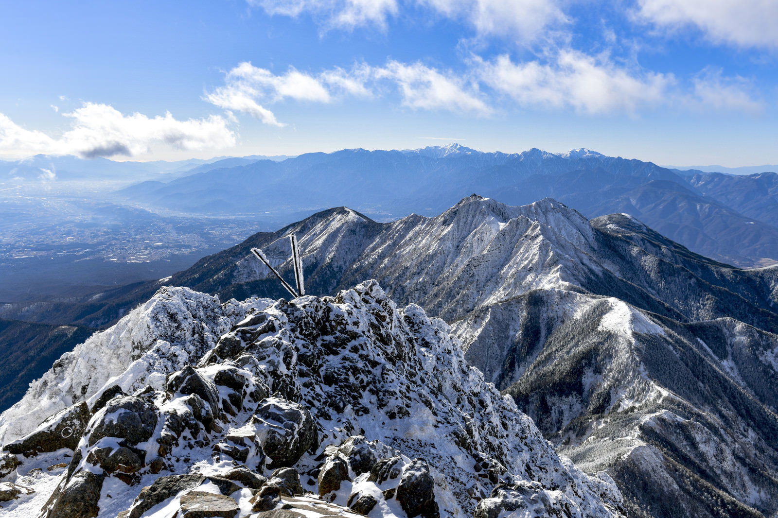 赤岳から望む雪化粧した南アルプスの山並みと権現岳の風景