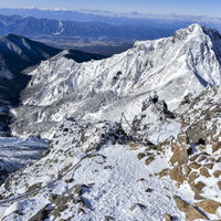 鎖の向こうに見える文三郎尾根と阿弥陀岳の雪景色の写真