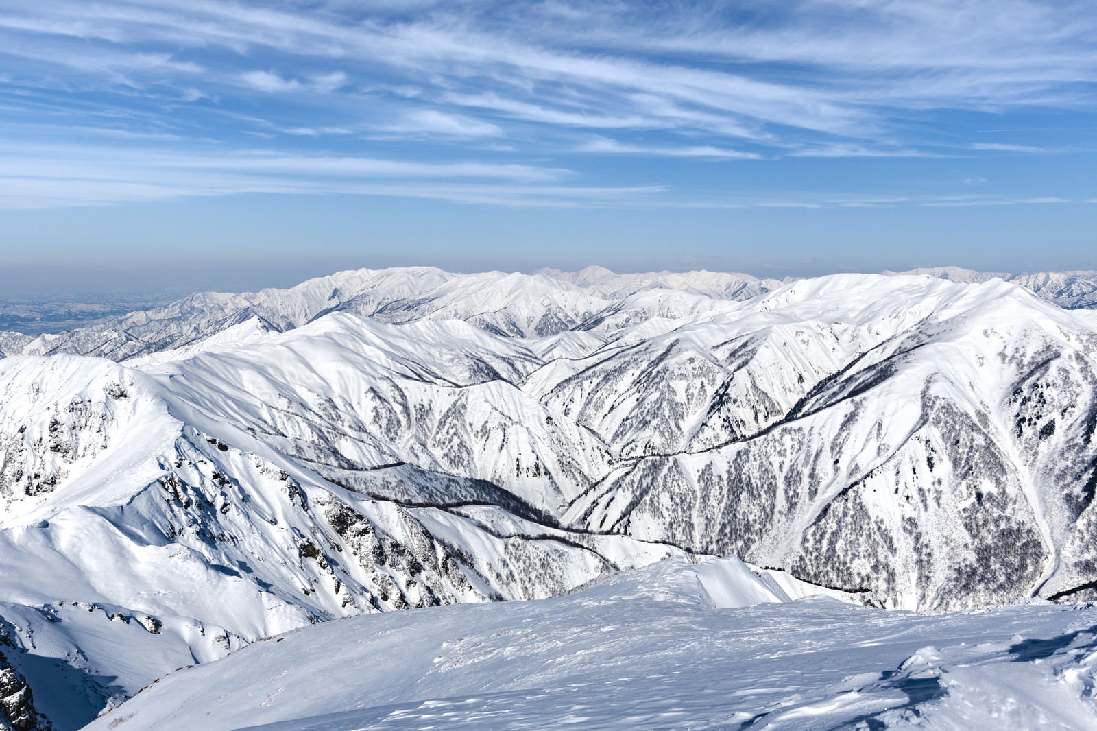 一ノ倉岳から撮影した雪化粧した上越の山並みと青空