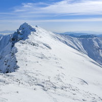 一ノ倉岳から望む雪に覆われた谷川岳の山頂の写真