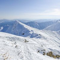 午後の日差しが差すオキの耳から眺めた雪の谷川岳・トマの耳の写真