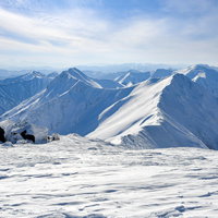 午後の陽気に照らされる谷川方の小屋と谷川主脈の写真