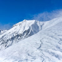 地吹雪が吹き付ける谷川岳中腹と川棚ノ頭方面の冬景色の写真