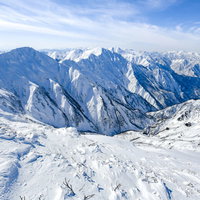 雪に覆われた谷川岳の巨大な山々が連なる景色の写真