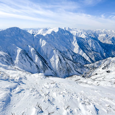 雪に覆われた谷川岳の巨大な山々が連なる景色の写真