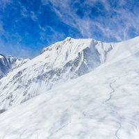 谷川岳の川棚ノ頭方面に巻きあがる雪煙と青空のコントラストの写真