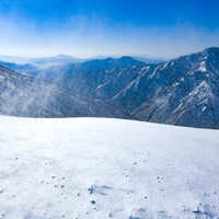 強風が吹き荒れる雪山・谷川岳中腹からの景色の写真