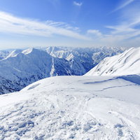 茂倉岳へと続く雪化粧した道と谷川主脈の稜線の写真