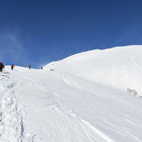 雪に覆われた谷川岳を登る登山者たちの冬山風景の写真