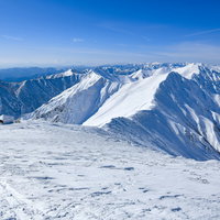 谷川方の小屋と凍てつく谷川主脈の雪景色 冬の登山風景の写真