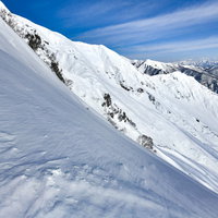 雪と岩が露出した谷川岳の急斜面の写真
